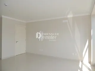 Interior de uma sala de estar com paredes brancas e piso claro.