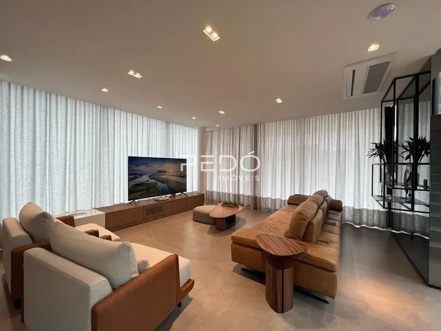Sala de estar com sofá e televisão em um imóvel.