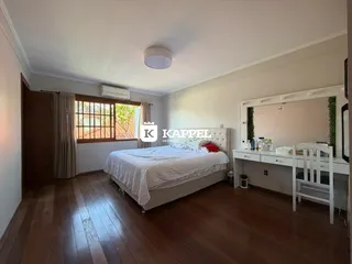 Quarto com cama de casal e janela com vista para a vegetação externa.