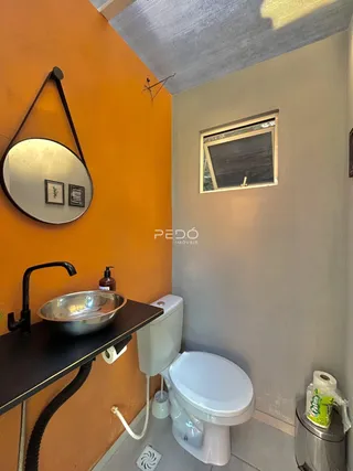 Foto do interior de um banheiro com paredes laranjas.