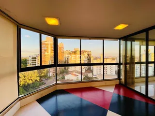 Sala de estar com vista panorâmica da cidade através de grandes janelas.