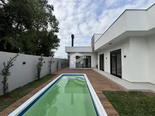 Vista da fachada de uma casa moderna com piscina no Brasil.