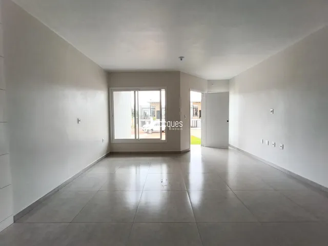 Corredor interno de uma residência com piso claro e paredes brancas.