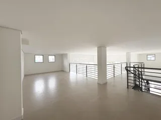 Vista interna de um ambiente amplo com paredes brancas.