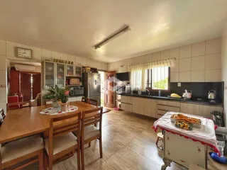 Uma sala de jantar com cozinha e armários de madeira no interior da propriedade.