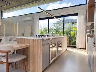 Cozinha moderna com ilha e grandes janelas de vidro.