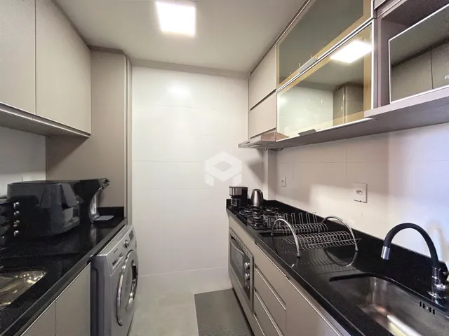 Cozinha moderna com armários e bancadas escuras.