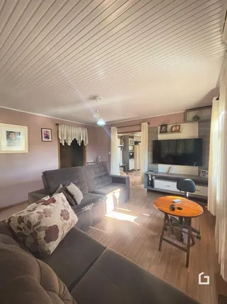 Sala de estar com sofá e piso de madeira.