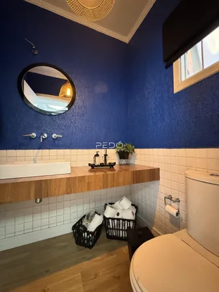 Foto de um banheiro com paredes azuis e revestimento de azulejos brancos.