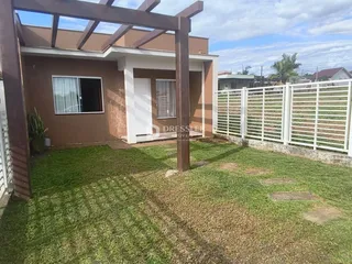 Foto da fachada de uma residência em Lajeado, Brasil, com jardim frontal e cerca branca.