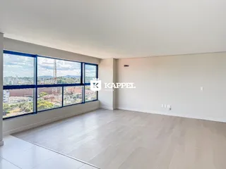 Sala ampla com grande janela oferecendo vista panorâmica da cidade.