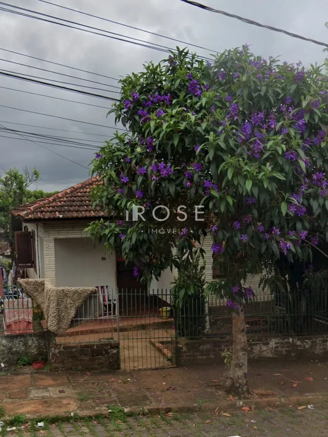 Fachada de uma residência em Lajeado, Brasil, coberta por vegetação florida.