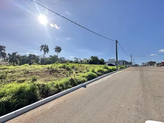 Vista da propriedade com campo gramado e estrada.