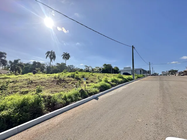 Vista da propriedade com campo gramado e estrada.
