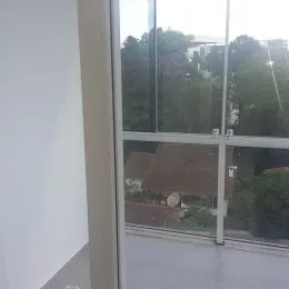 Vista externa da propriedade mostrando vegetação e estruturas ao fundo.