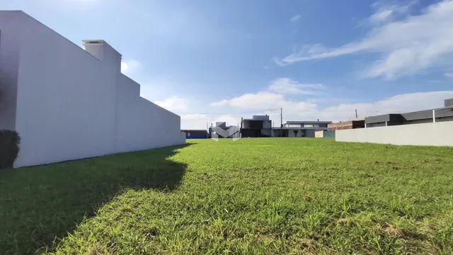 Fachada de um imóvel com grande área gramada verde.
