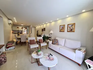 Sala de estar com sofá branco e mesa de jantar.