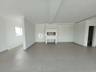 Foto de uma sala de estar ampla com paredes brancas e piso claro.