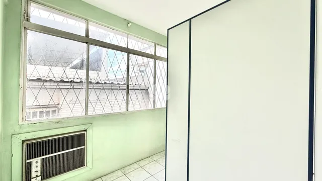Vista da janela de uma sala com parede verde claro.