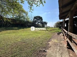 Um campo gramado com árvores ao fundo é visível nesta foto de uma propriedade.