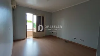 Sala de estar com piso de madeira clara e porta de vidro.
