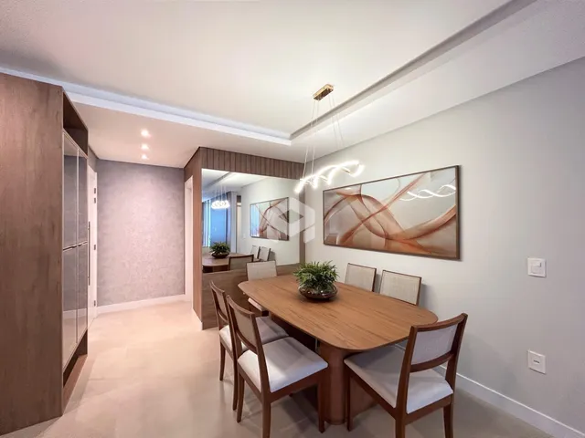 Foto de uma sala de jantar com mesa de madeira e cadeiras em um imóvel no Brasil.