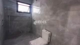 Foto interna de um ambiente com paredes cinzas e uma janela.