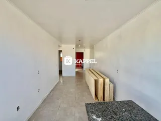 Corredor interno de uma residência com paredes brancas e piso de cerâmica.