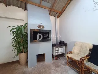 A sala apresenta um teto de madeira aparente e paredes brancas.