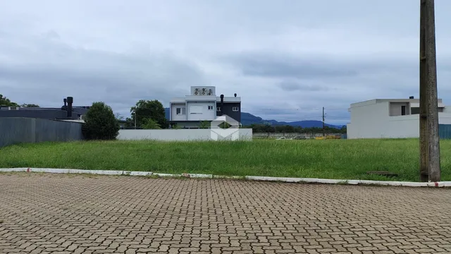 Fachada de residências em Lajeado, Brasil, com jardim em primeiro plano.