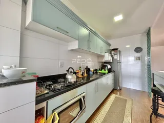 Foto de uma cozinha moderna com armários brancos e bancada escura.