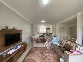 Sala de estar moderna com sofá e televisão em um apartamento.