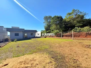 A fachada de uma casa moderna em Lajeado, Brasil, com área externa em desenvolvimento.