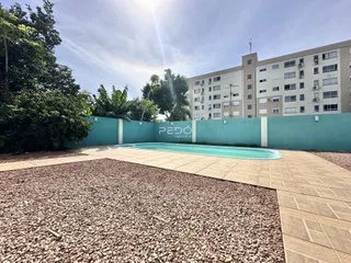 Vista externa de uma propriedade com piscina e jardim.