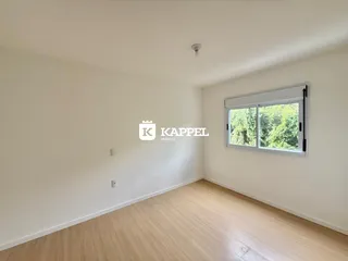 Foto de um cômodo interno com piso de madeira e uma janela.