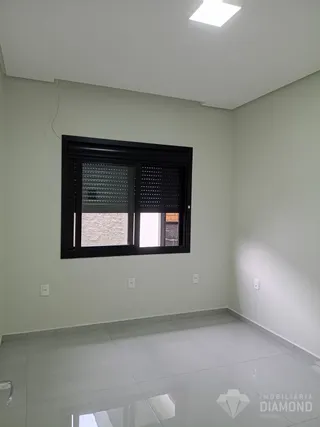 Interior de um cômodo com paredes claras e piso de cerâmica.