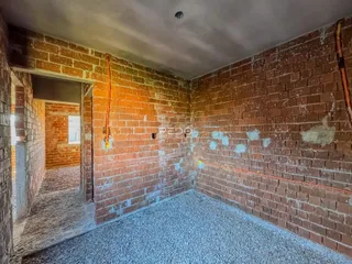 Parede de tijolos aparentes com acabamento desgastado em um interior.