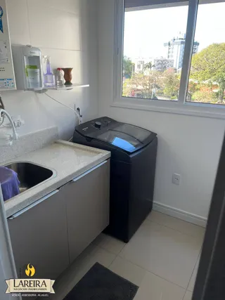 Foto de uma cozinha com janela e armários brancos.