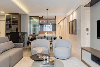 Sala de estar moderna com sofás e mesa de centro em um apartamento.