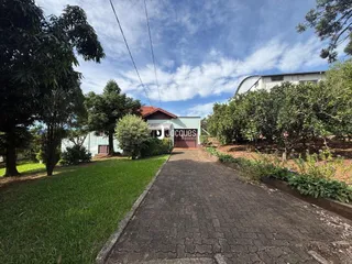 Vista externa de uma propriedade em Lajeado, Brasil, com jardim e estrada.
