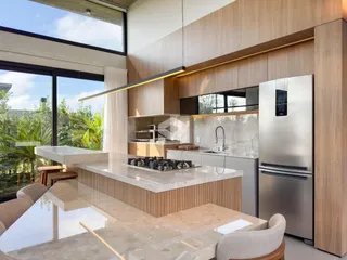Cozinha moderna com ilha e grandes janelas que oferecem vista para a paisagem externa.
