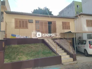 Foto da fachada de uma casa em Lajeado, Brasil, com jardim frontal e escadaria.