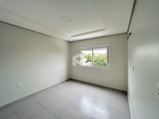 Uma sala interna com piso de cerâmica e janela.