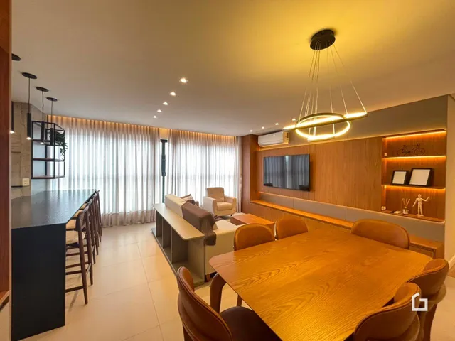 Sala de estar e jantar com piso de madeira e painéis na área interna.
