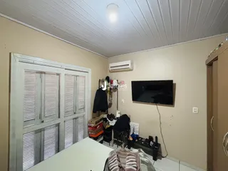Quarto com janela de veneziana e ar condicionado instalado.