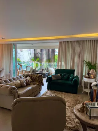Sala de estar com sofá e cortinas em um imóvel no Brasil.