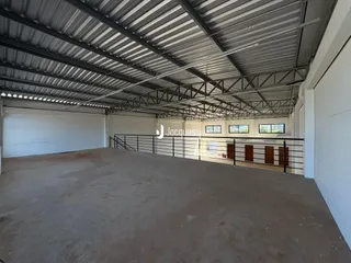 Foto de um espaço interno com estrutura de metal e piso de concreto cru.