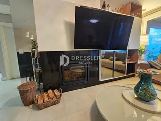Sala de estar com lareira e televisão na área de lazer.