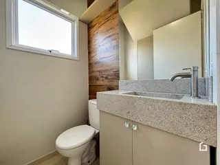 Foto de um banheiro com bancada e vaso sanitário.
