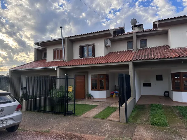 Vista externa de uma residência em Lajeado, Brasil, com muro e portão de ferro.